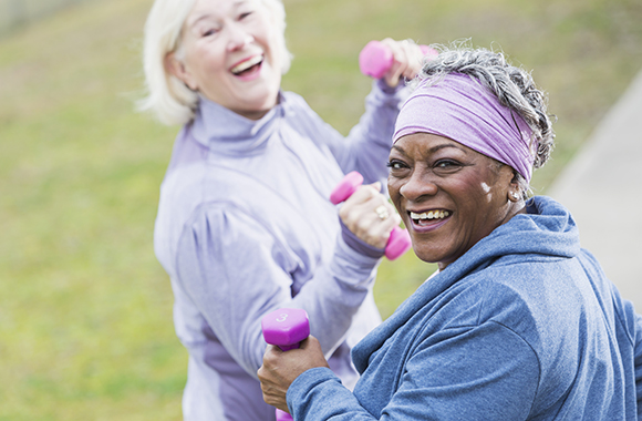 Senior women (60s) exercising in park.  Focus on African American woman.
